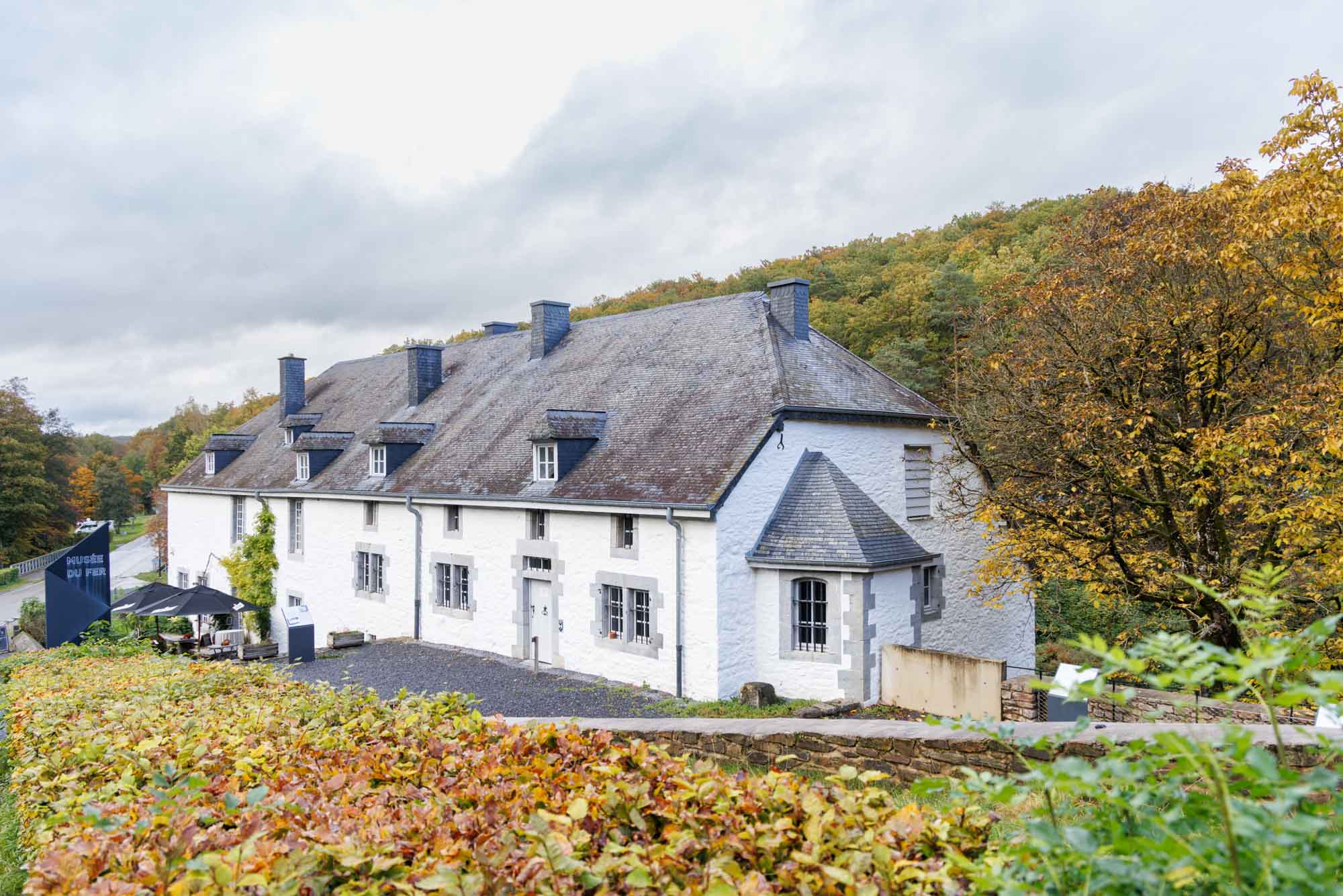 Musée du Fer au Fourneau Saint-Michel devant la forêt aux couleurs d’automne