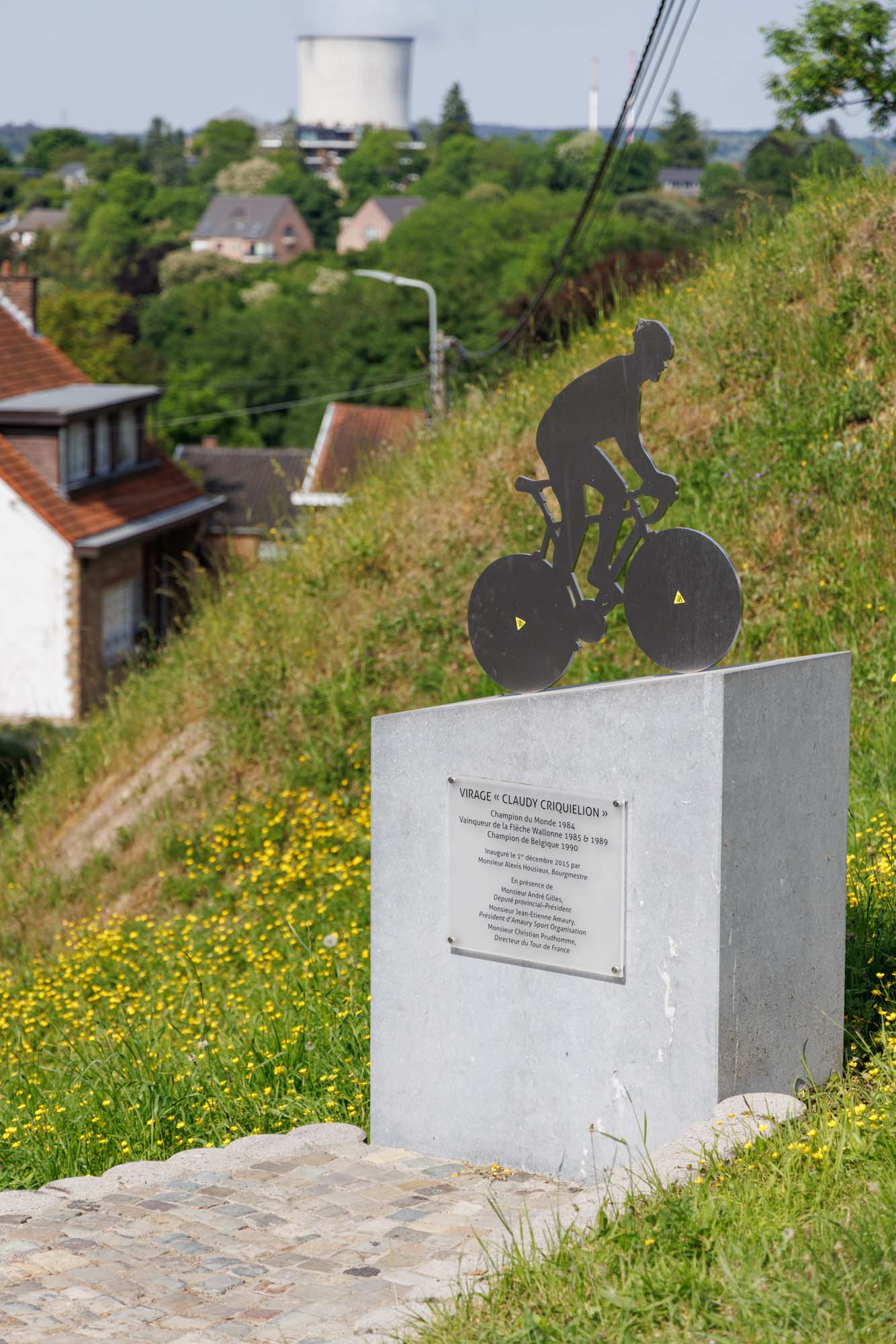 Stèle du mur de Huy avec silhouette de cycliste sur socle, au bord de la célèbre montée.